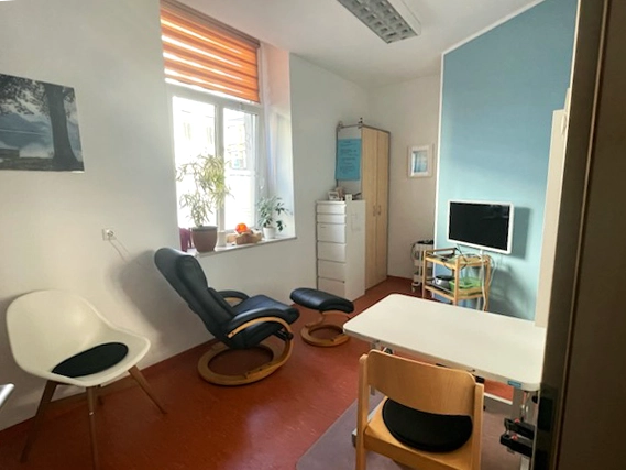 Heller Therapieraum der Ergotherapie-Praxis ergovision in Döbeln mit Tisch, Stühlen und Entspannungsstuhl