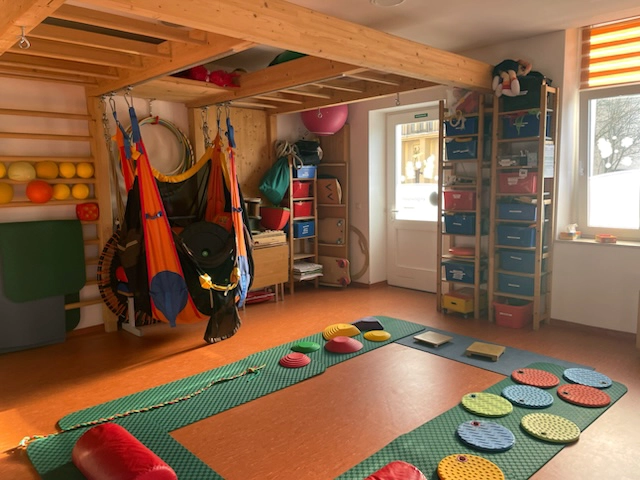 Pädiatrischer Ergotherapieraum in Döbeln mit Bewegungsparcours, Schaukeln und Therapiegeräten für Kinder