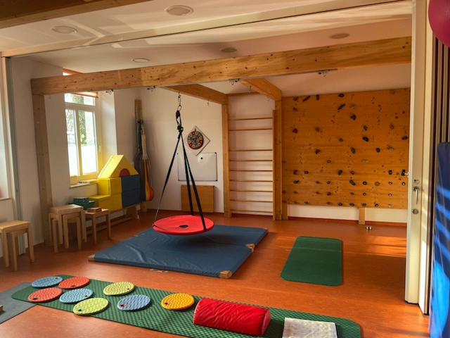 Bewegungsraum für Kinder-Ergotherapie in Döbeln mit Kletterwand, Schaukel und motorischen Übungsmatten