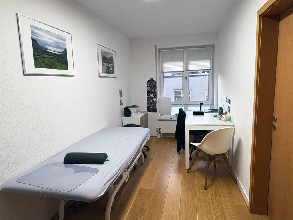 Behandlungsraum für Ergotherapie in Leipzig mit Therapieliege, Arbeitsplatz und freundlichem Praxisambiente